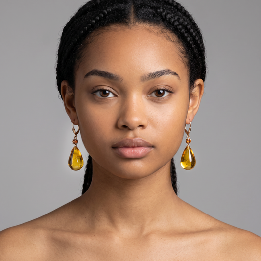 Trebor Style 18k gold drop earrings featuring a tourmaline accent and a large, hand-cut golden amber gemstone.