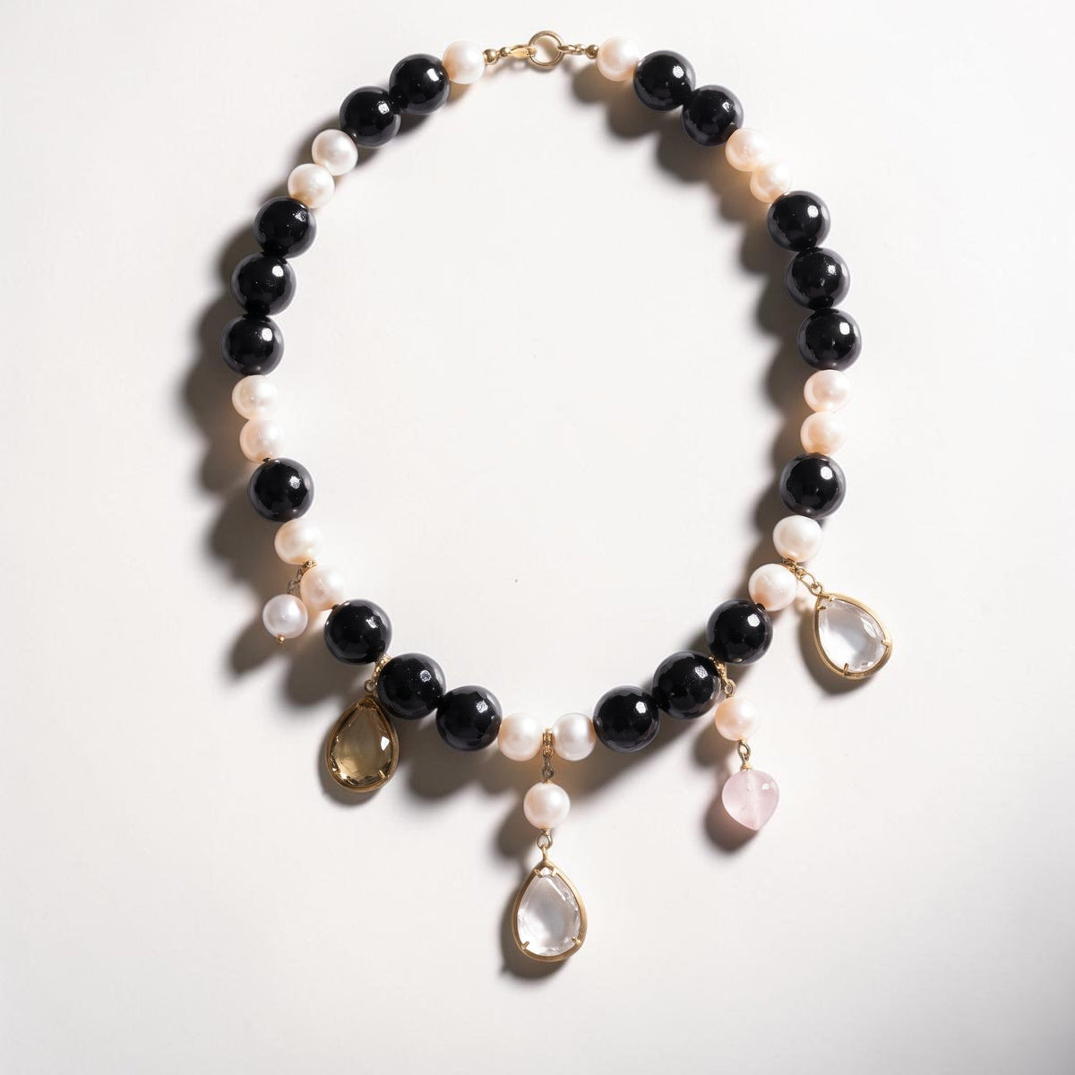 Trebor Style black onyx and white pearl necklace with 18k gold and dangling pink and amber quartz charm drops.