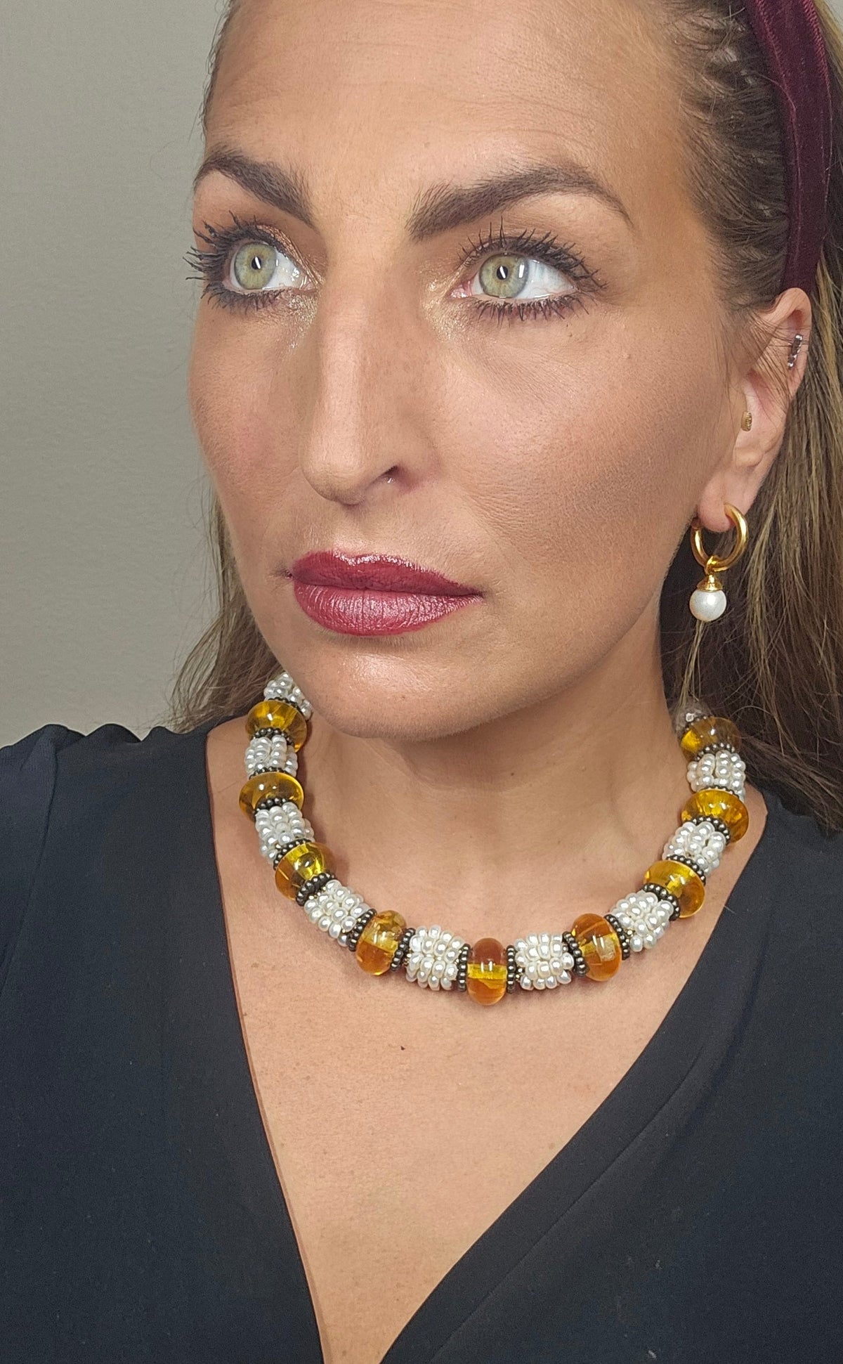 Trebor Style Masha Archer necklace featuring freshwater pearls and Baltic amber rondelles on a model