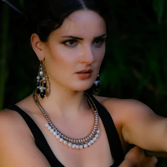 Trebor Style necklace featuring white pearls, black tourmaline, and Murano glass beads worn by a woman.