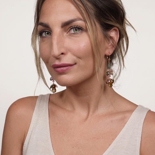 Trebor Style 14k yellow gold dangle earrings featuring multi-color pink and green tourmaline gemstones on a model.