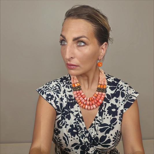 Trebor Style Masha Archer triple strand coral necklace with orange rondelles, pewter beads, and a coin clasp on model