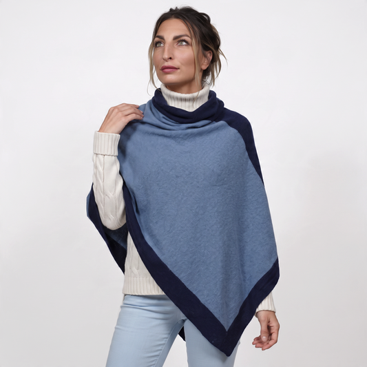 Trebor Style two-tone heather blue and navy cashmere blend poncho worn by a woman over a white turtleneck sweater.