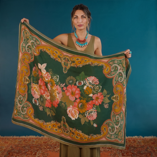 Trebor Style folk art floral print scarf in pink, green, and cream polyester held by a woman against a teal backdrop