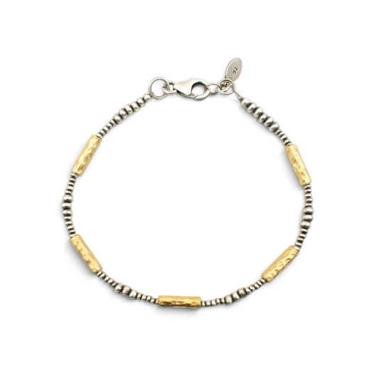Trebor Style hammered 14K vermeil tube and sterling silver bead bracelet with lobster clasp on marble background.