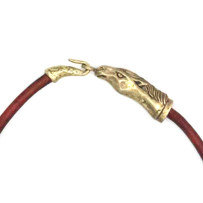 Trebor Style Wild Spirit horse choker featuring a sculpted gold patina horse head clasp on a brown leather cord.