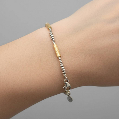 Trebor Style hammered 14k vermeil and sterling silver mixed metal bracelet worn on a wrist