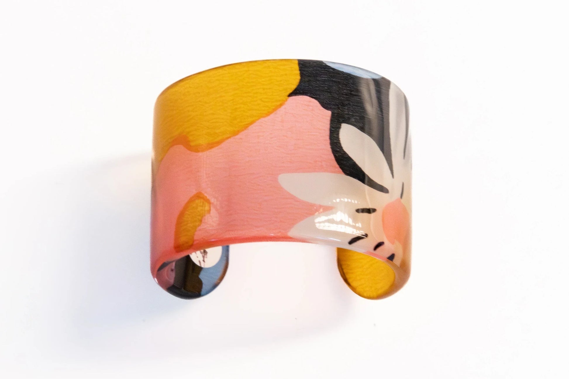 Trebor Style resin cuff bracelet featuring a vibrant abstract floral pattern in yellow, pink, and black.