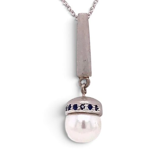 Trebor Style Akoya pearl pendant necklace with blue sapphire accents on a brushed sterling silver bale and chain.