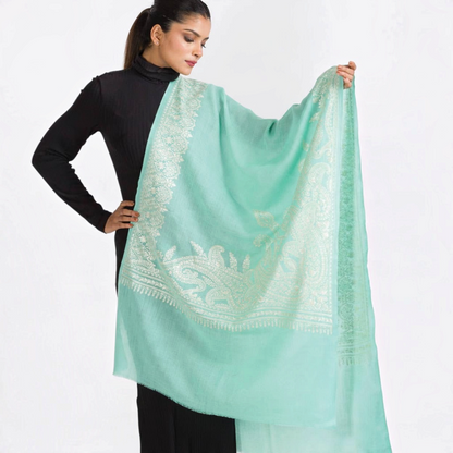 Trebor Style aqua merino wool shawl with intricate ivory embroidery worn by a model against a white background
