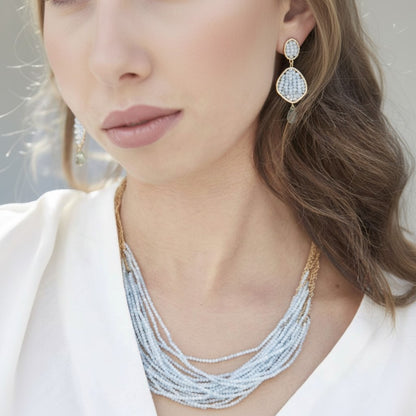 Trebor Style Aquamarine Dolores necklace with 18 strands of blue stones and 14k gold-filled cable chain on a model