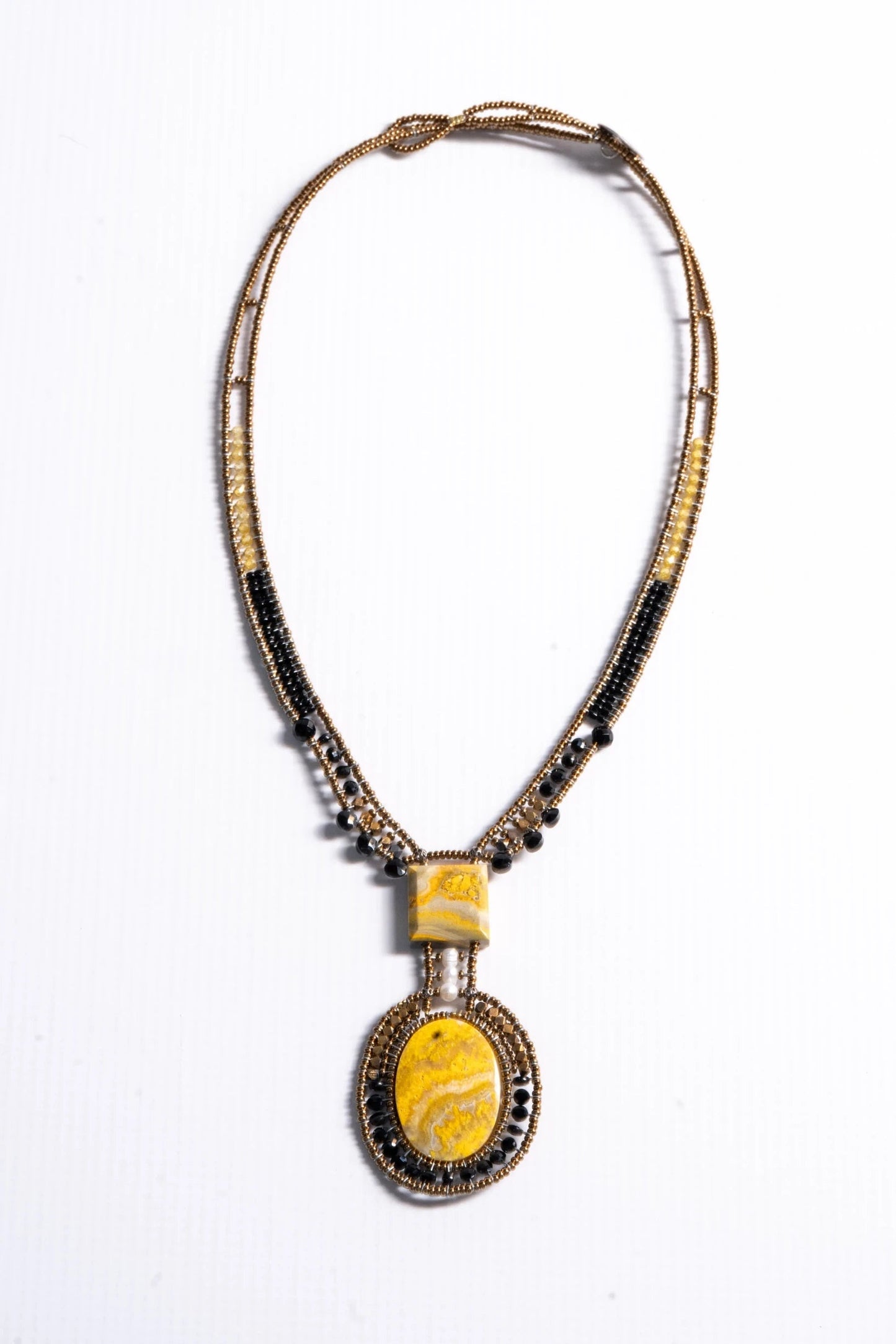 Trebor Style artisan statement necklace featuring yellow jasper stones, bronze, gold, and black beads with a pearl.