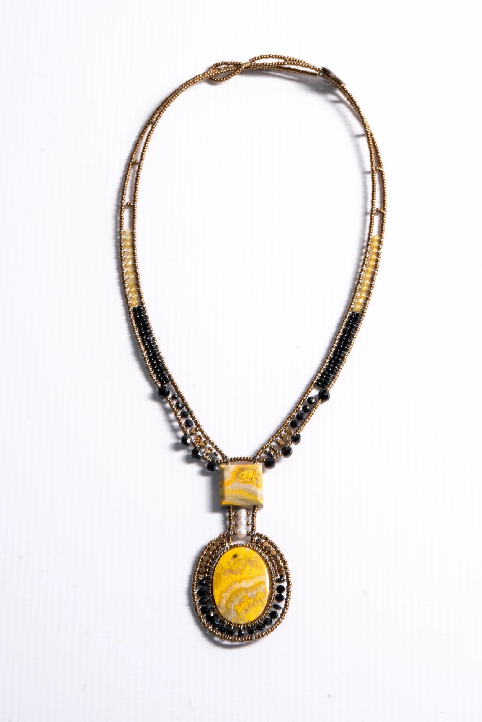 Trebor Style artisan statement necklace featuring yellow jasper stones, bronze, gold, and black beads with a pearl.
