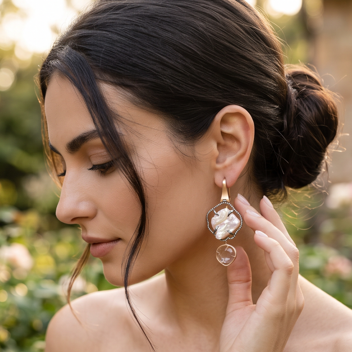 Trebor Style baroque pearl and pink quartz drop earrings with black diamond halo in 18k rose gold worn by a woman.