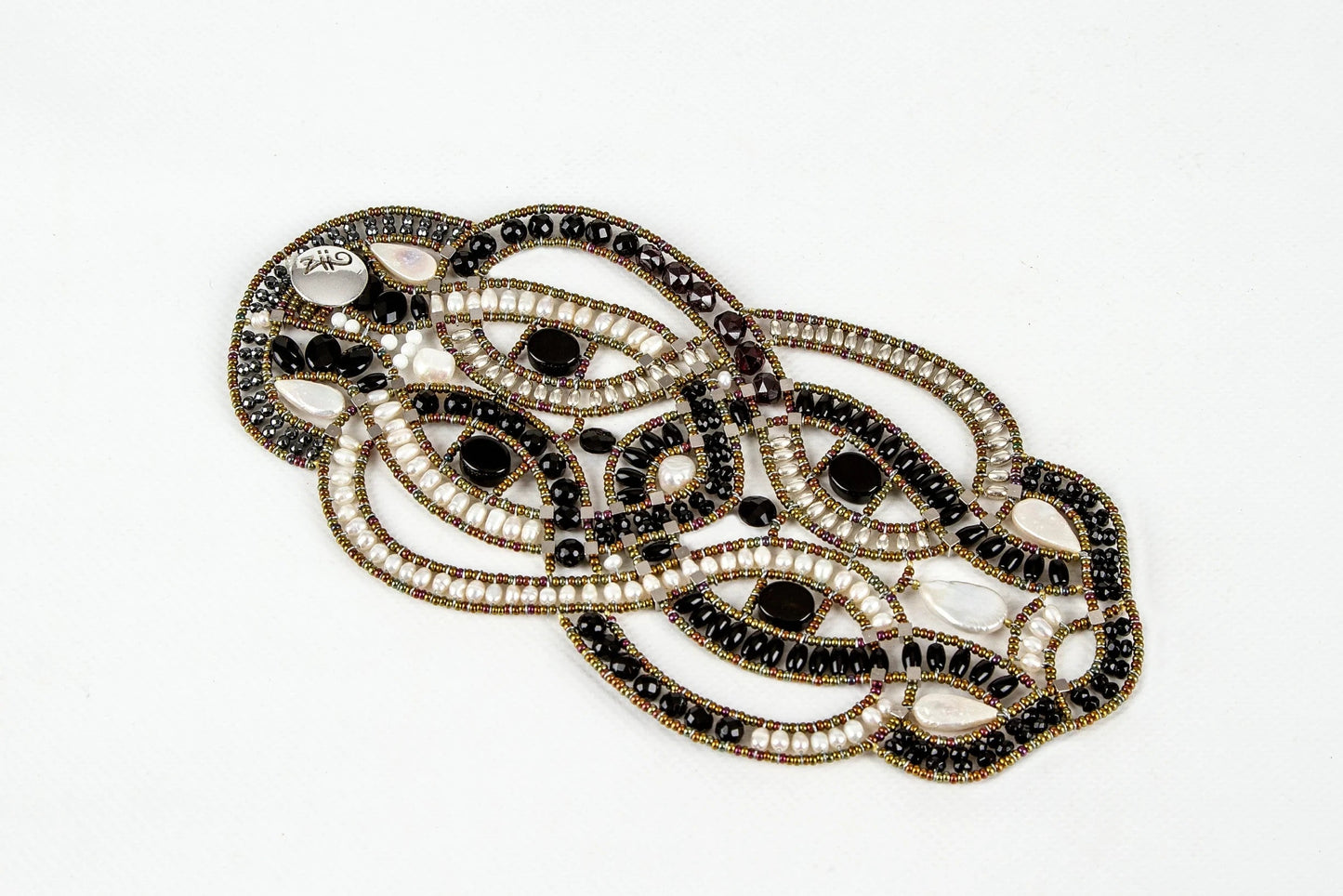 Trebor Style artisan statement bracelet featuring intricate woven lattice beadwork with black onyx and white pearls.