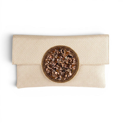 Trebor Style beige jute silk clutch featuring a central hand-embellished medallion with natural stone accents.