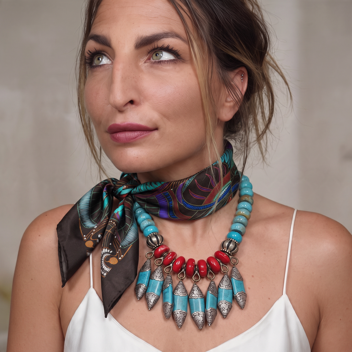 Trebor Style black silk satin tube scarf with jungle print worn by a woman with a turquoise and red statement necklace
