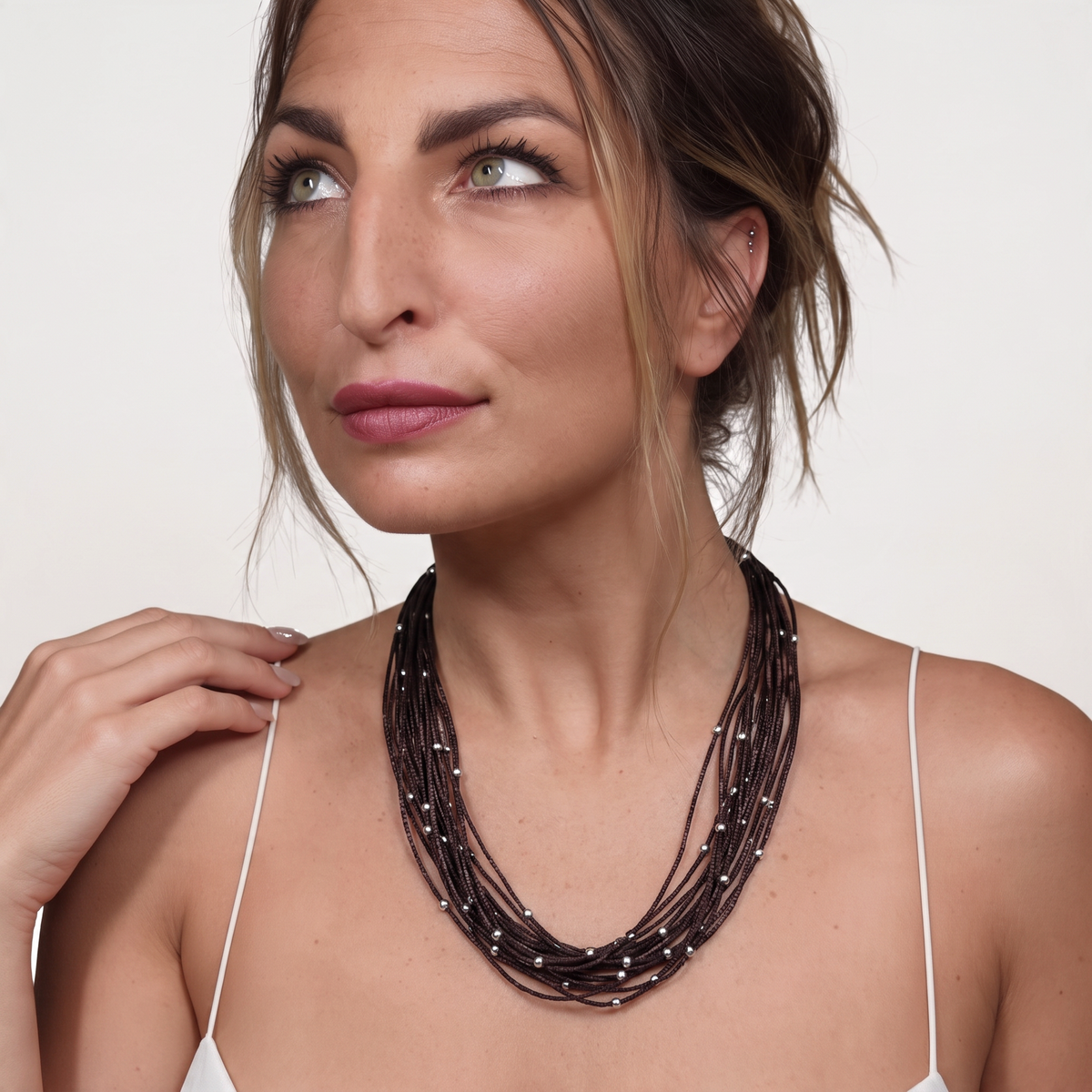 Trebor Style brown sterling silver thread choker necklace with silver beads worn by a woman against a white background