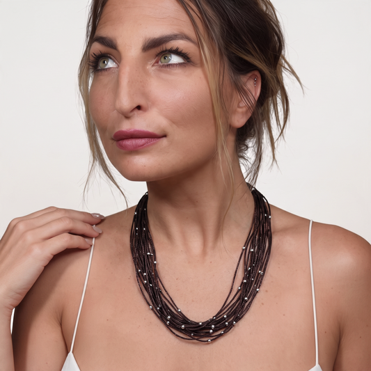 Trebor Style brown sterling silver thread choker necklace with silver beads worn by a woman against a white background