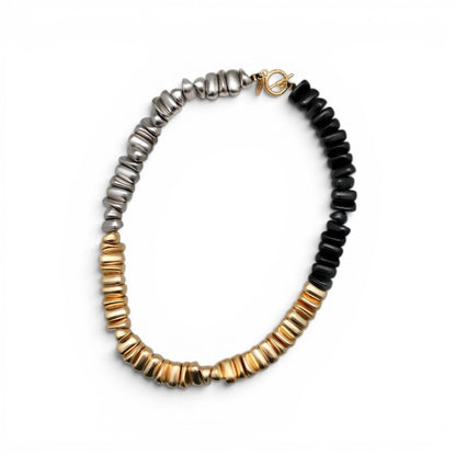 Trebor Style Calista three-tone statement necklace with gold, silver, and black pebble-shaped beads on a toggle clasp.