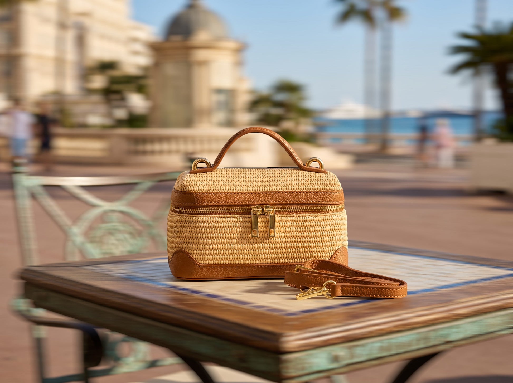 Trebor Style camel woven top-handle beach bag with a structured silhouette, gold hardware, and detachable strap.