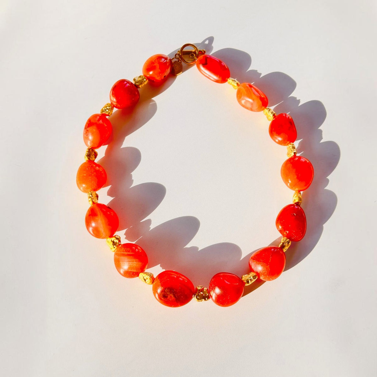 Trebor Style organic carnelian gemstone necklace with gold-plated brass toggle clasp and vibrant orange stones.