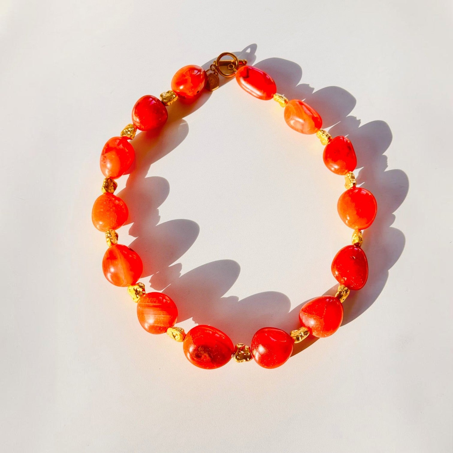 Trebor Style organic carnelian gemstone necklace with gold-plated brass toggle clasp and vibrant orange stones.