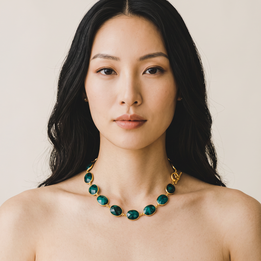 Trebor Style faceted emerald bezel-set toggle necklace worn by a woman with long dark hair against a neutral background