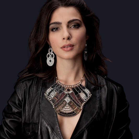 Trebor Style Falena statement bib necklace featuring onyx, garnet, and pearls worn by a woman in a leather jacket.