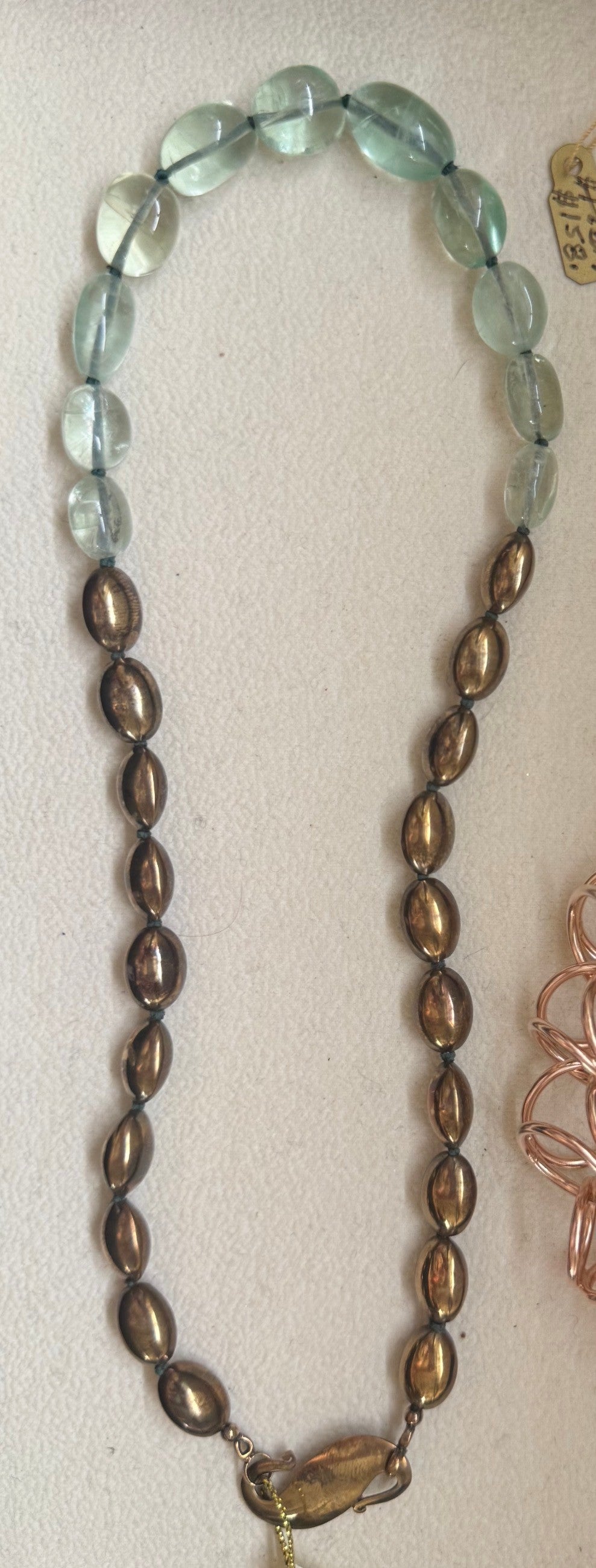 Trebor Style handcrafted statement necklace featuring pale green fluorite beads and metallic bronze oval accents.