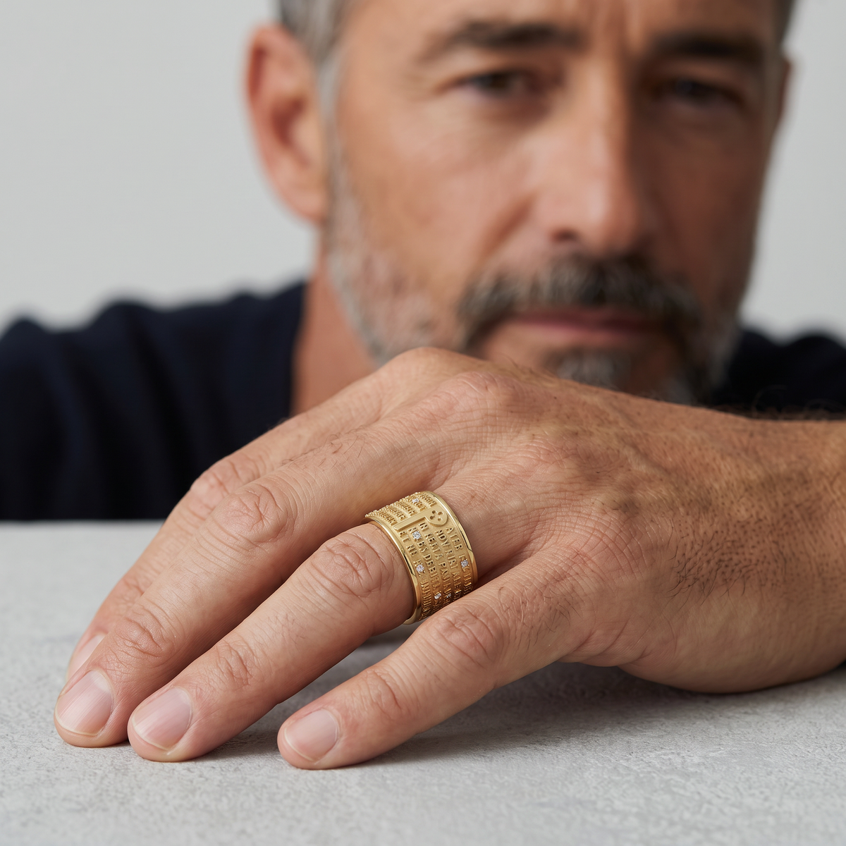 Trebor Style 18k yellow gold TUUM Our Father ring with diamond-encrusted P detail worn on a man's finger