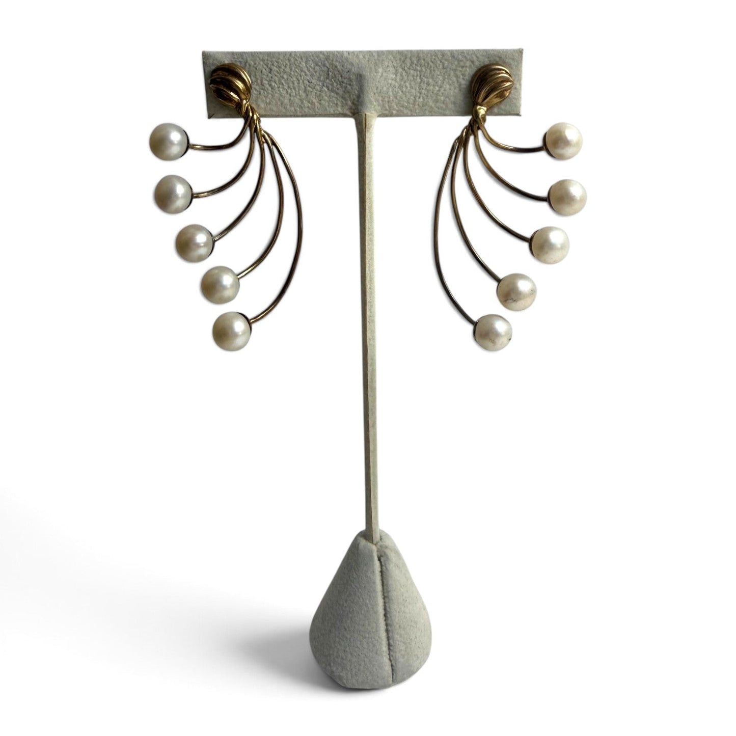 Trebor Style gold-tone fan-style statement earrings featuring five cascading cream-colored faux pearls on a display.