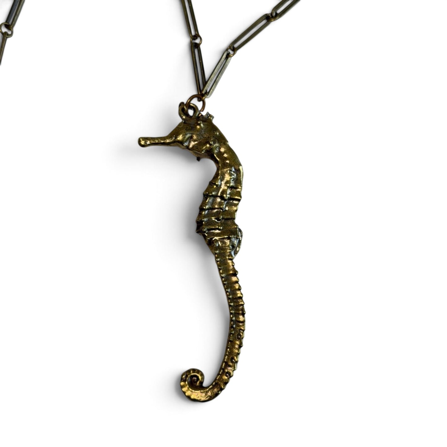 Trebor Style seahorse necklace in gold patina with an intricate link chain, symbolizing oceanic grace and strength.