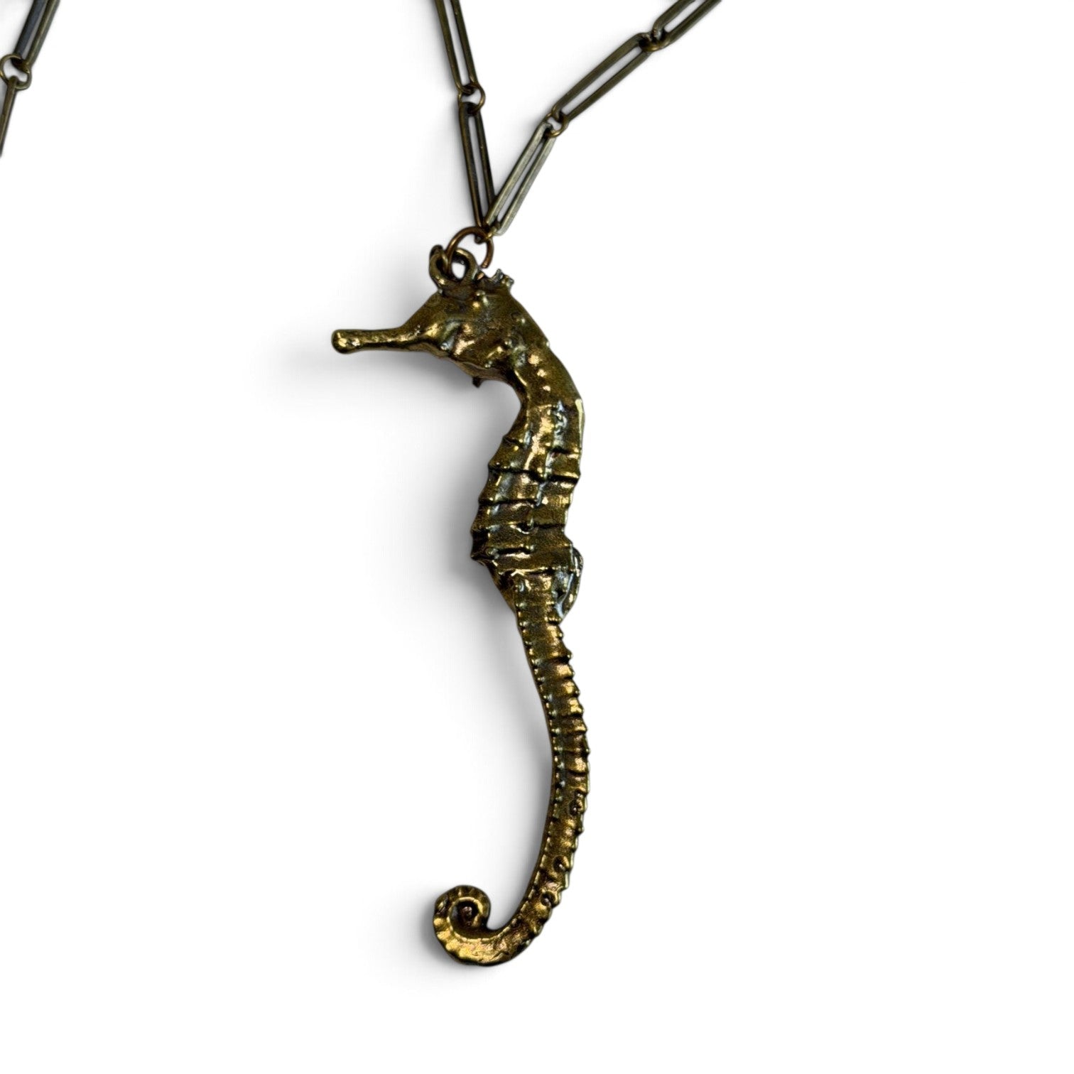 Trebor Style seahorse necklace in gold patina with an intricate link chain, symbolizing oceanic grace and strength.