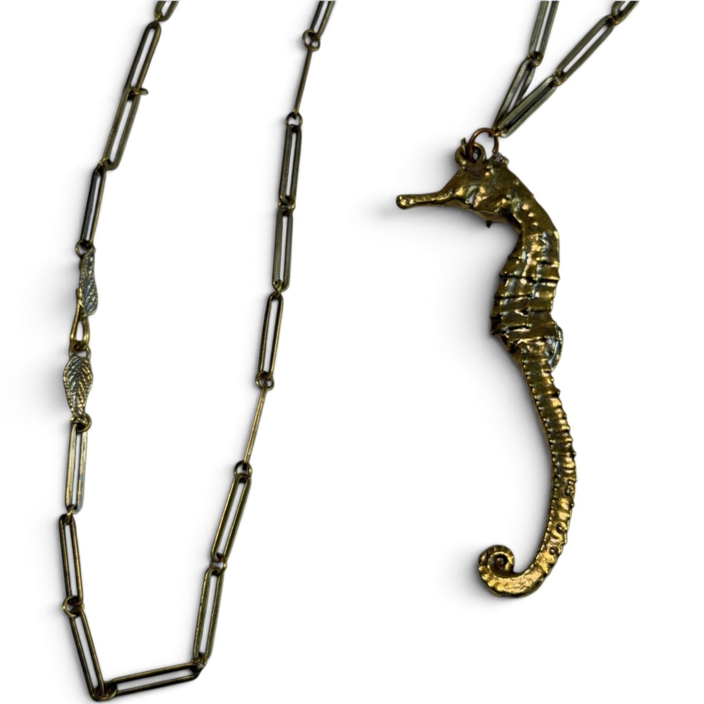 Trebor Style seahorse necklace in gold patina with a textured seahorse pendant and a delicate leaf clasp chain.