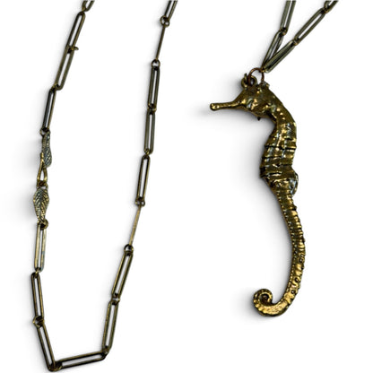 Trebor Style seahorse necklace in gold patina with a textured seahorse pendant and a delicate leaf clasp chain.