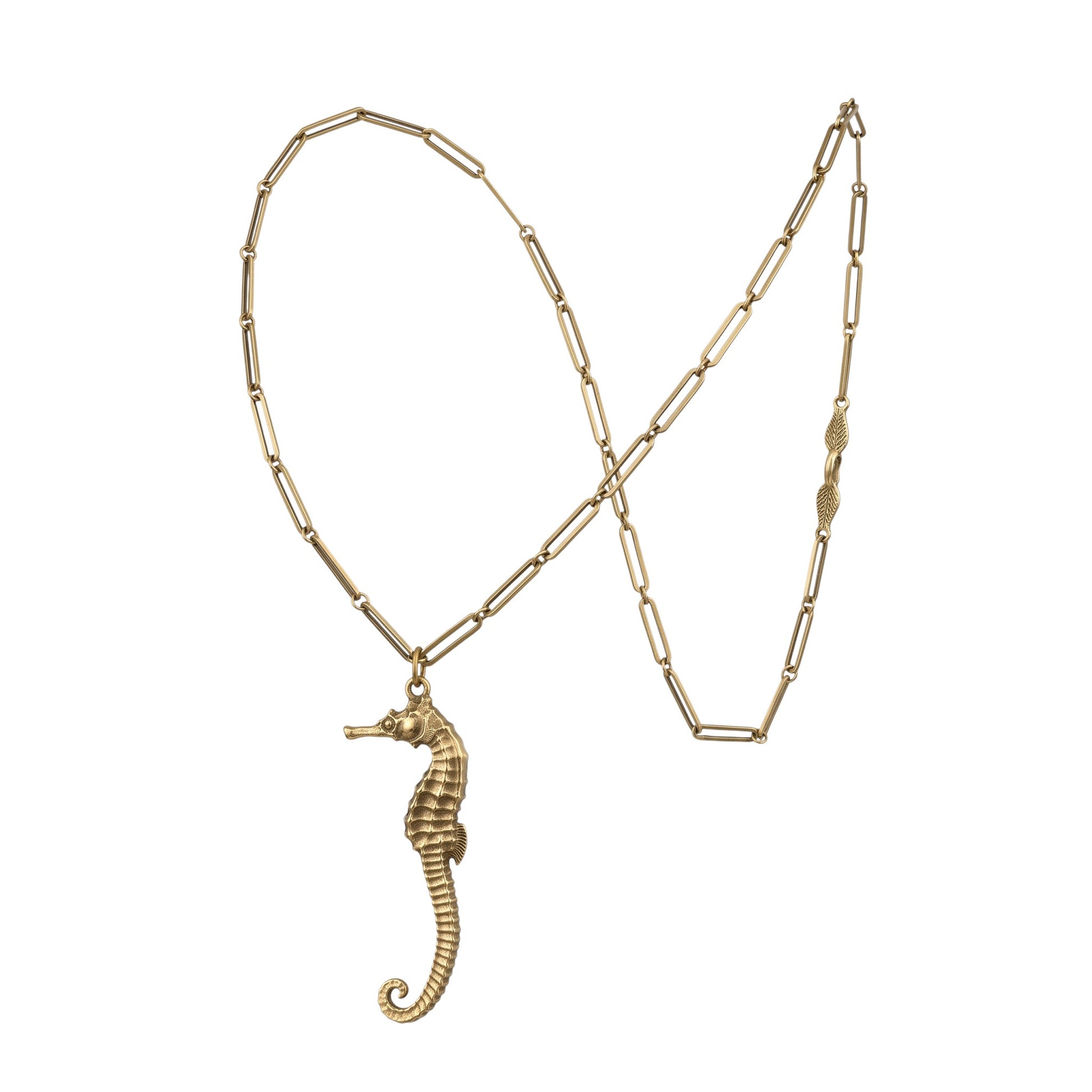 Trebor Style gold seahorse pendant necklace on a delicate paperclip chain with an intricate leaf clasp detail.