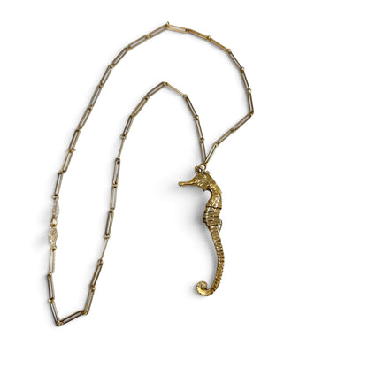 Trebor Style gold seahorse pendant necklace on a delicate paperclip chain with an intricate leaf clasp detail