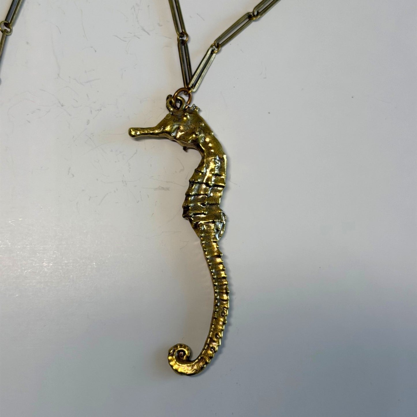 Trebor Style seahorse necklace in signature gold patina with an intricate link chain on a white background.