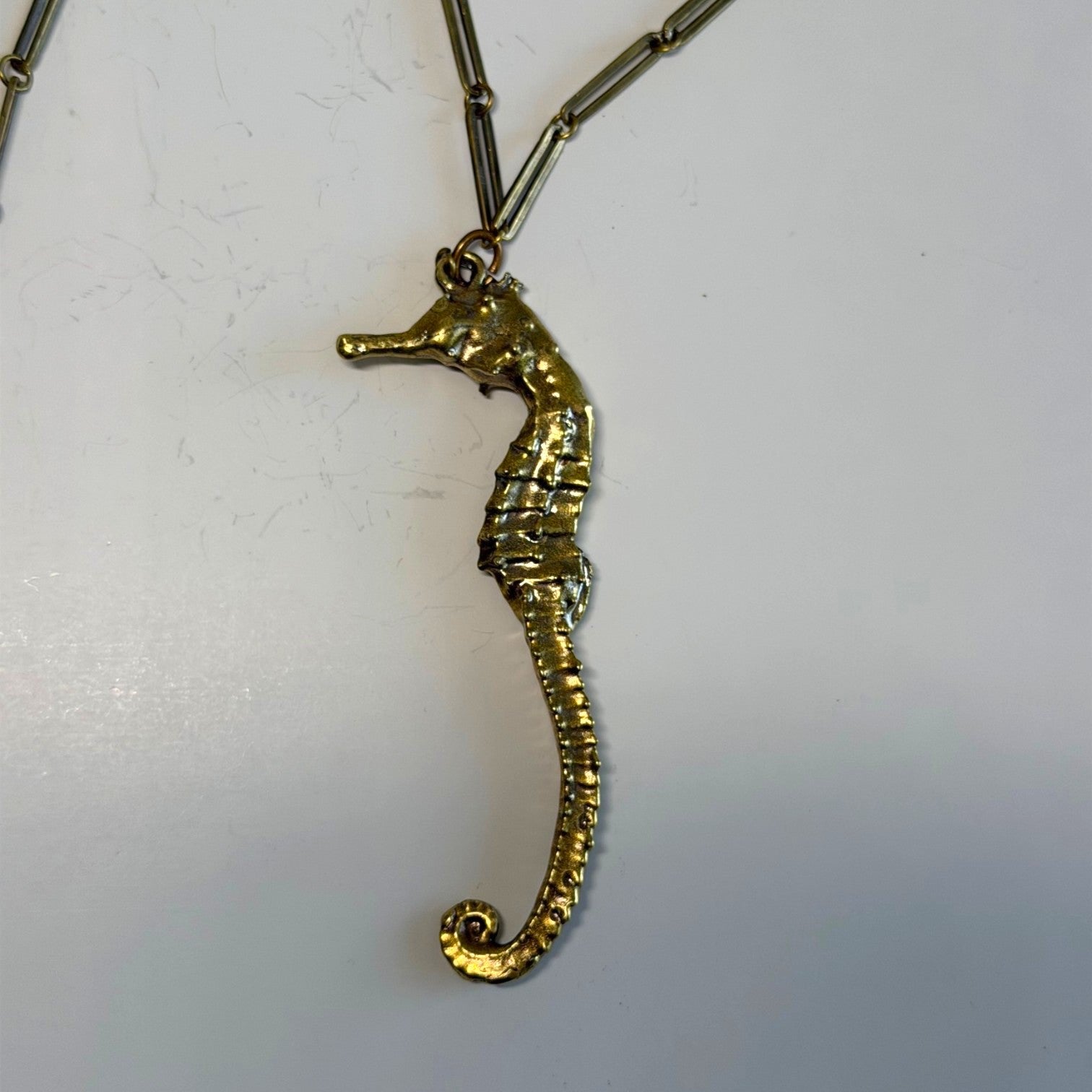 Trebor Style seahorse necklace in signature gold patina with an intricate link chain on a white background.