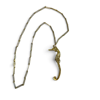Trebor Style gold seahorse pendant necklace with a delicate link chain and intricate leaf clasp detail