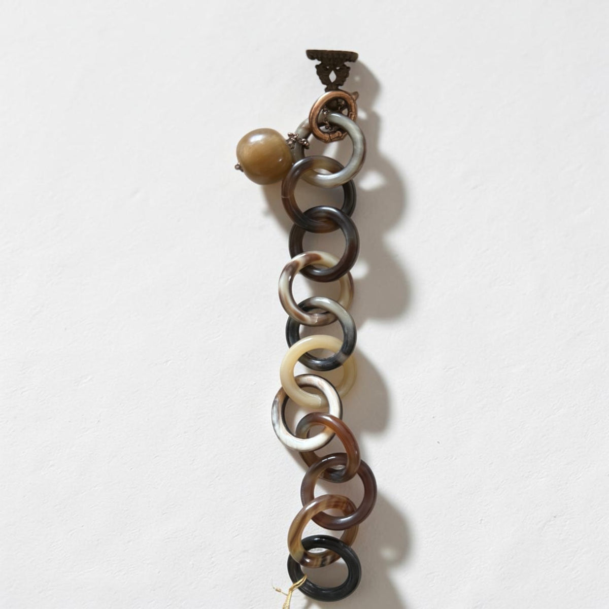 Trebor Style Amle bracelet featuring interlocking brown and tan natural horn circular links with horn and metal charms.