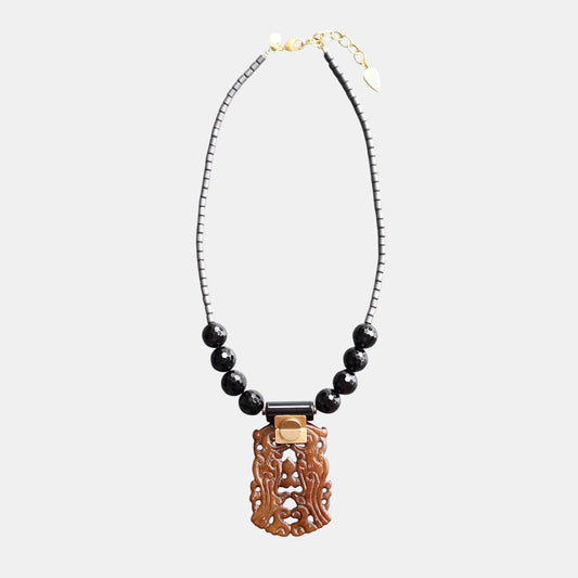 Trebor Style necklace featuring a carved brown jade pendant, black agate beads, and hematite accents on a beaded chain.