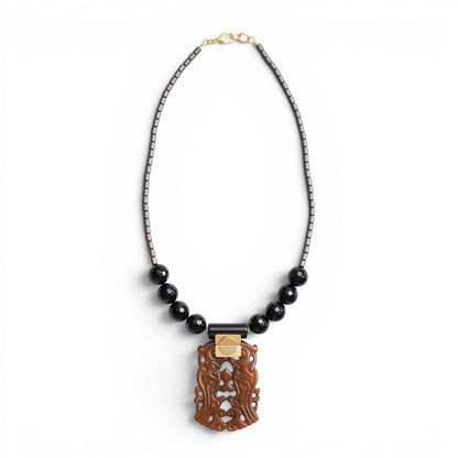 Trebor Style necklace featuring a carved jade pendant, black agate beads, and hematite accents on a beaded chain.