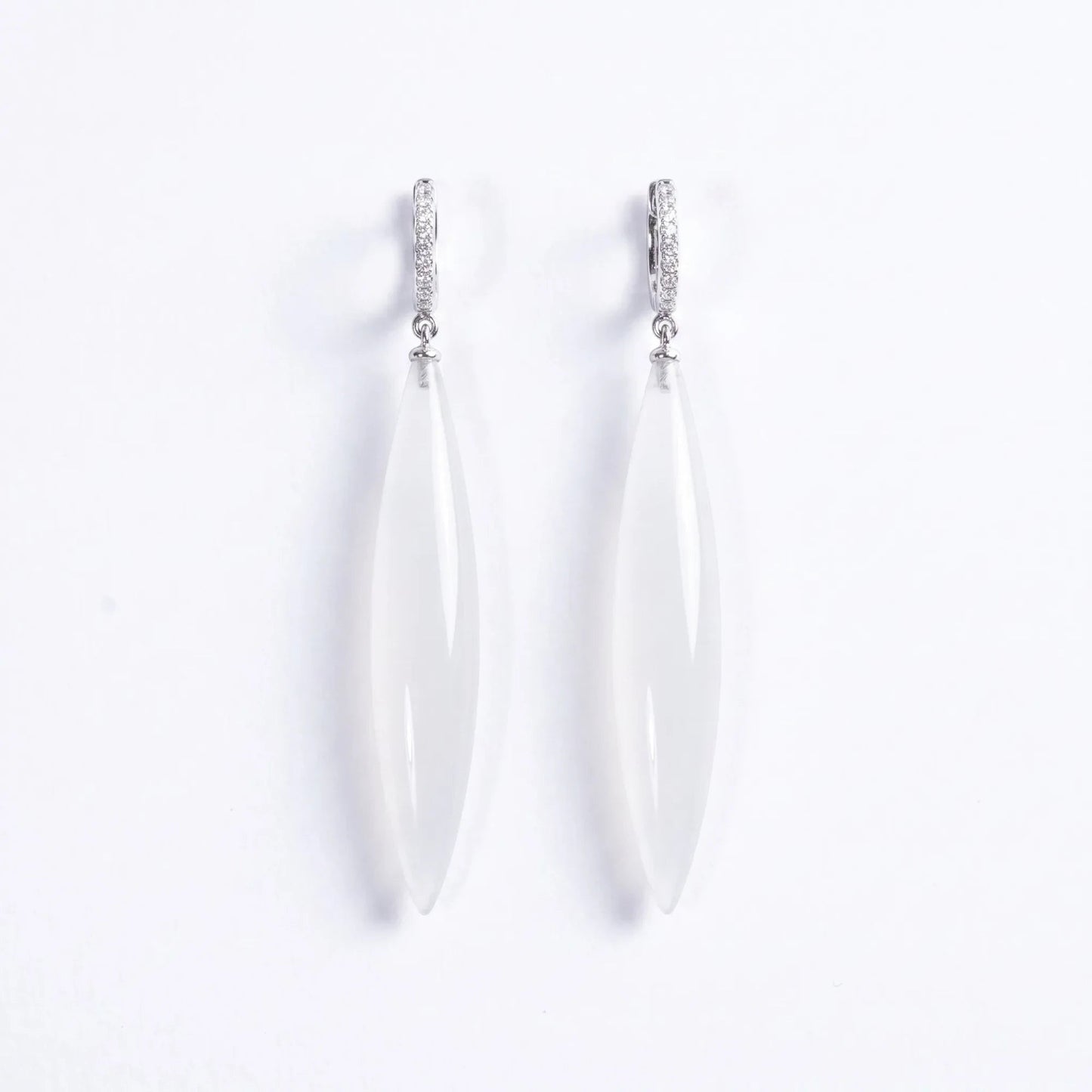 Trebor Style long drop earrings featuring translucent white stone pendants on silver-tone pavé hoop settings.