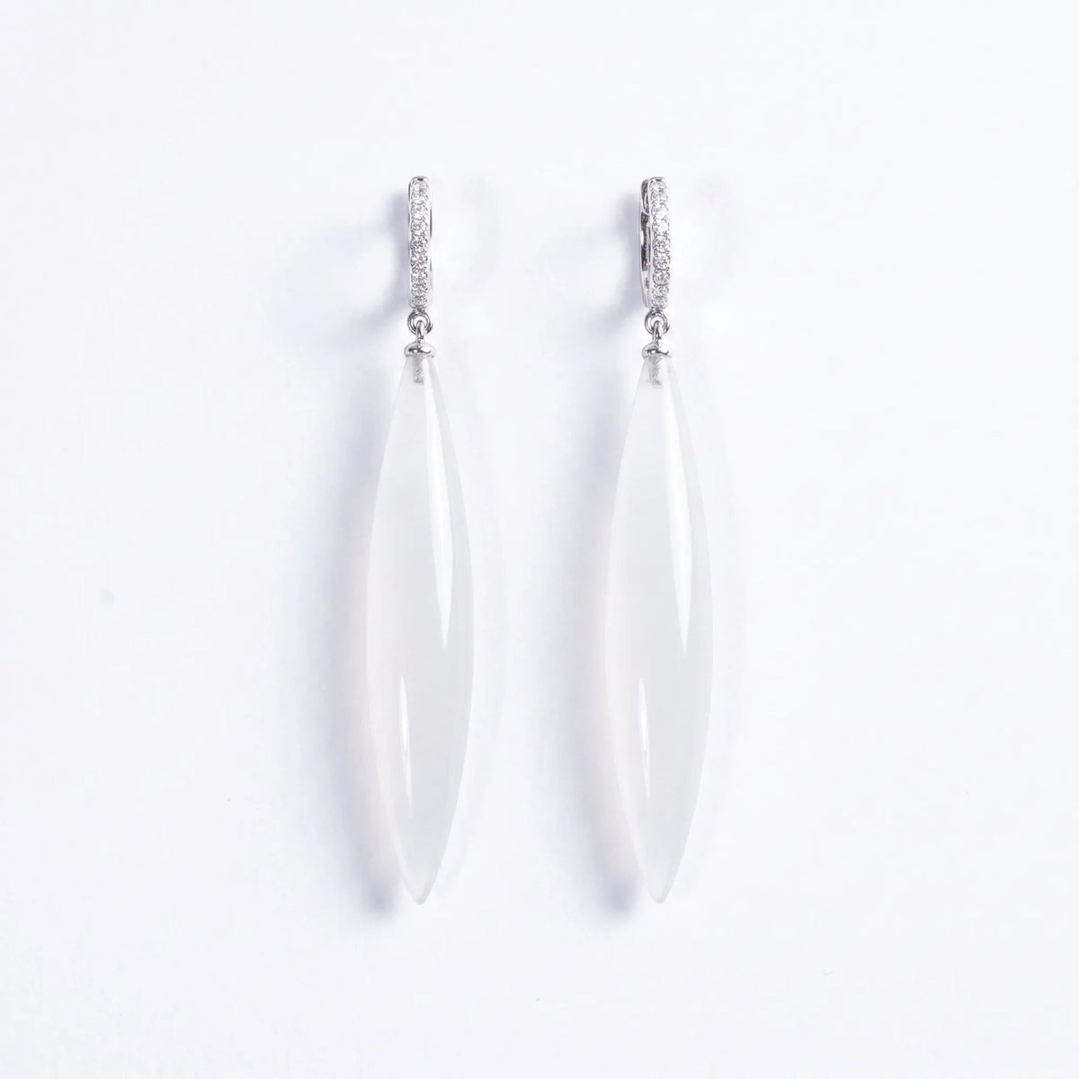 Trebor Style long drop earrings featuring translucent white stone pendants on silver-tone pavé hoop settings.