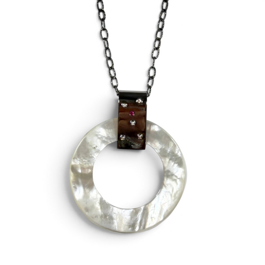 Trebor Style long necklace featuring a round mother of pearl pendant with diamond and ruby accents on oxidized silver