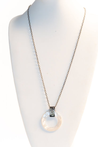 Trebor Style long necklace with a round mother of pearl pendant, diamond and ruby accents, on oxidized silver chain.