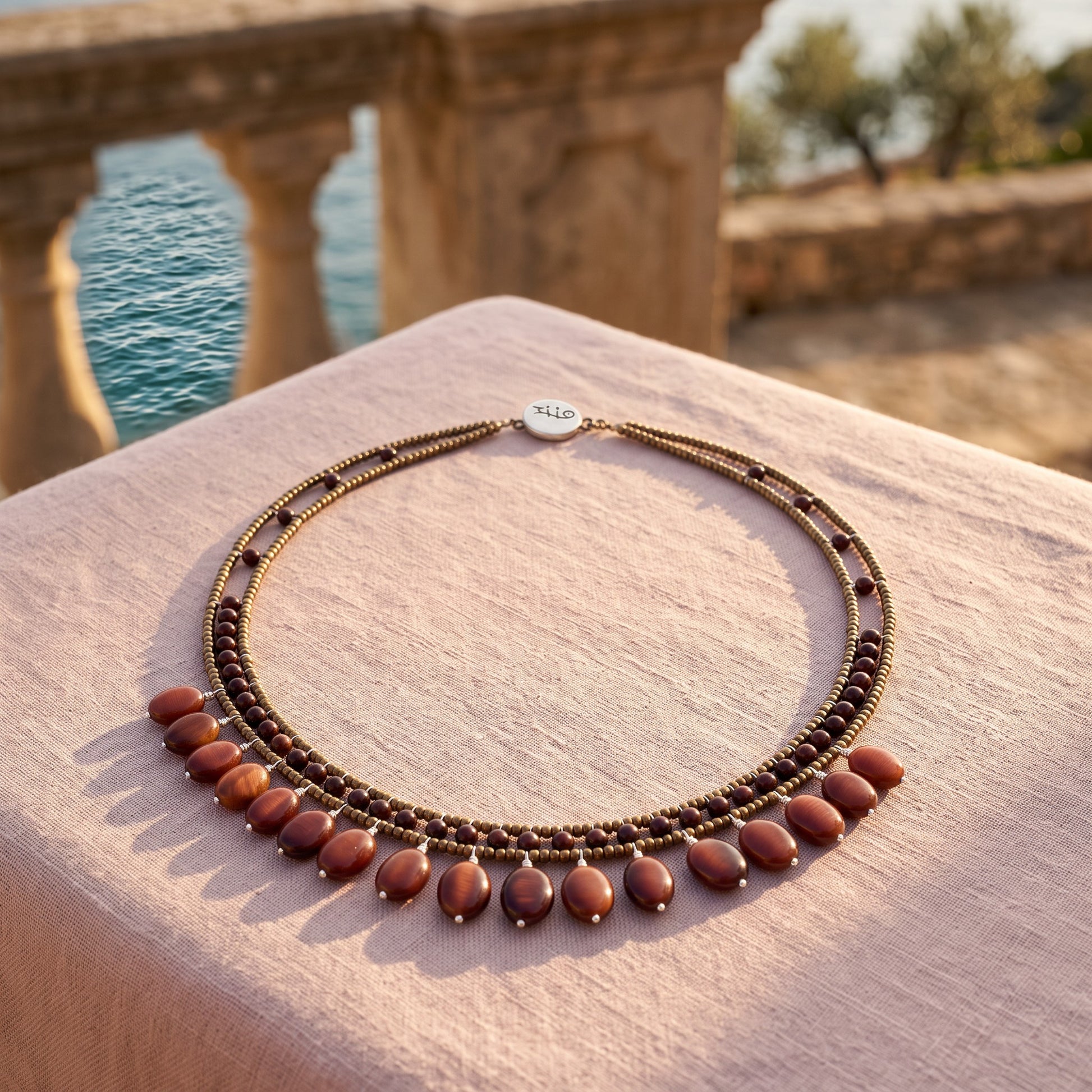 Trebor Style multi-strand beaded necklace with bronze seed beads, dark garnet accents, and dangling carnelian beads.