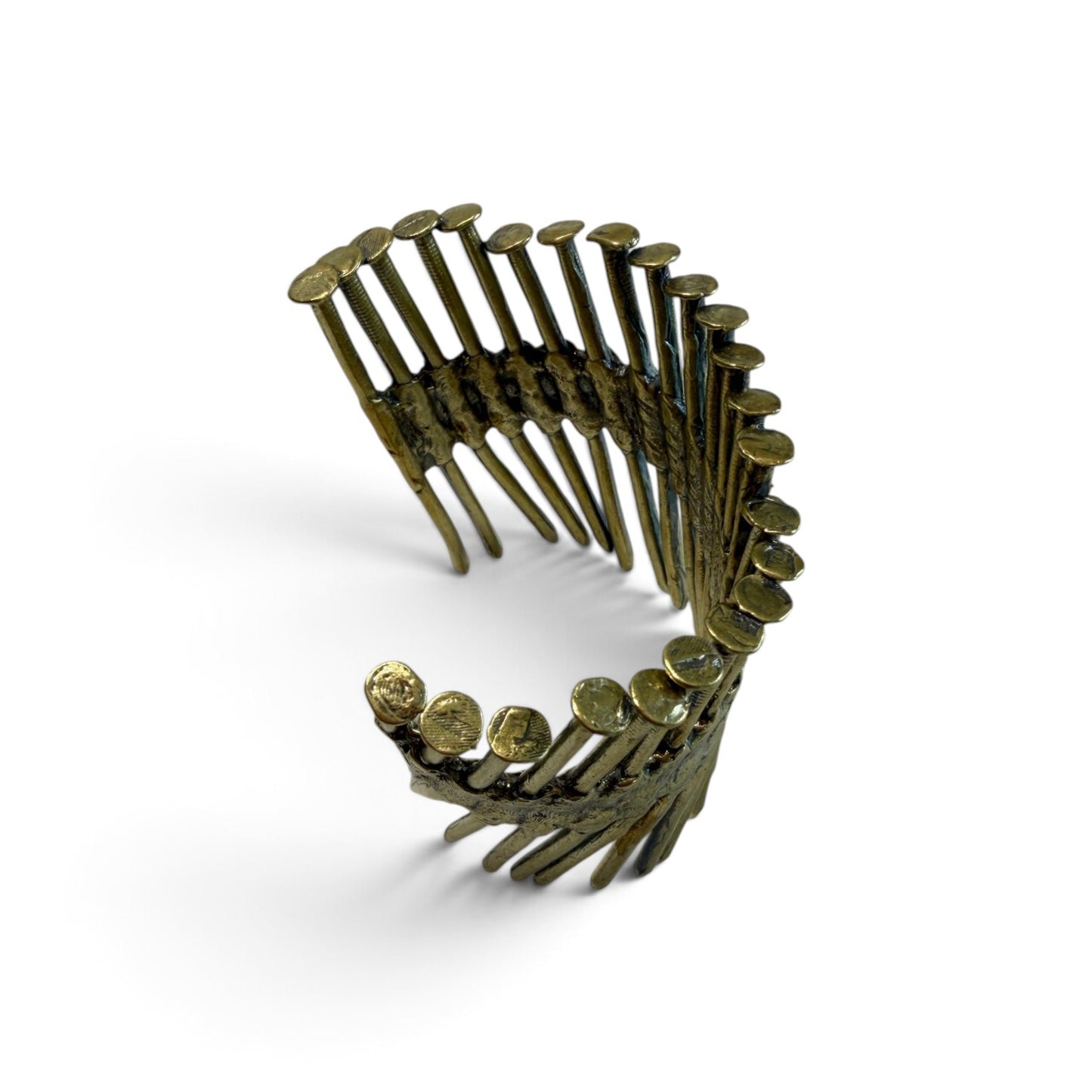 Trebor Style industrial cuff bracelet cast from a row of reclaimed metal nail gun nails in a raw brass finish.